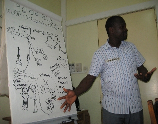 FLSMS Benin 002 My colleague Henri sharing the basic idea of the information flow and how it could intersect with a FrontlineSMS and Ushahidi system.